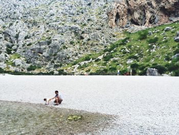 Side view of father with son on shore at torrente de pareis