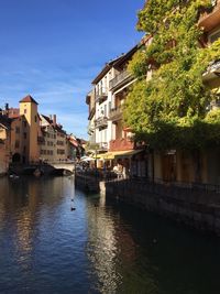 Canal amidst buildings in town against sky