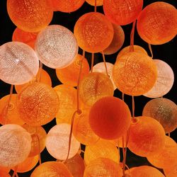 Close-up of illuminated orange lighting decoration against black background