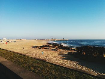 Scenic view of beach against clear blue sky