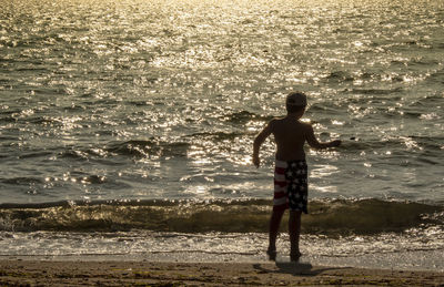 Rear view of man standing on beach