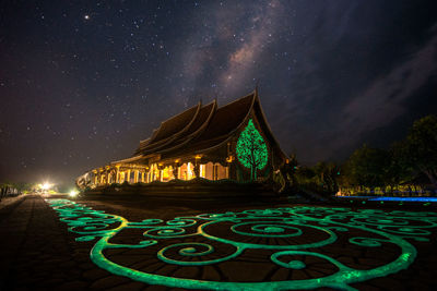 Panoramic view of illuminated building against sky at night