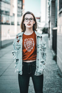 Portrait of young woman standing in city