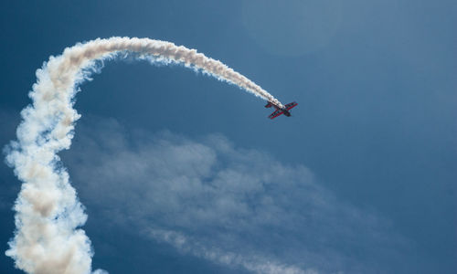 Low angle view of airplane flying against clear blue sky