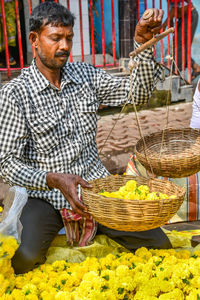 Full length of man standing in basket at market stall