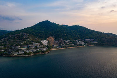 Scenic view of sea by city buildings against sky