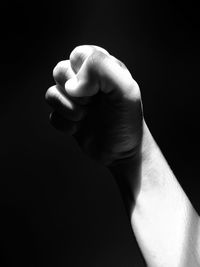 Close-up of human hand against black background