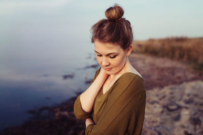 Beautiful woman standing at beach during sunset