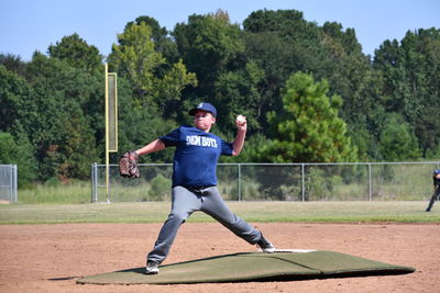 Full length of man standing on field against trees