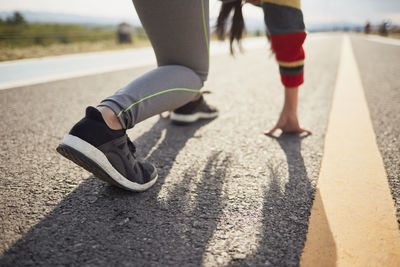 Low section of man skateboarding on road