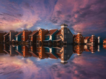 Reflection of buildings in city during sunset