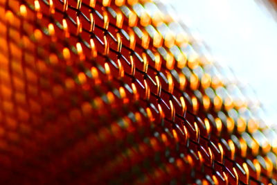 Abstract glowing metal spiral develops heat in orange hue against bright white surface