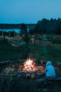 Rear view of man standing by lake