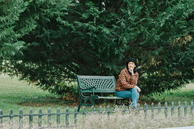 Woman sitting on bench in park