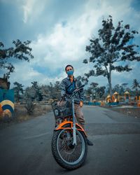 Man riding bicycle on road against sky