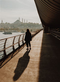 Rear view of woman walking on bridge