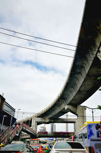 Low angle view of bridge in city against sky
