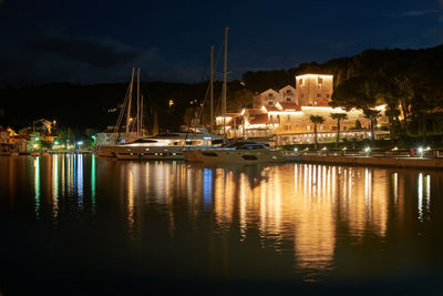 Sailboats moored in marina at night