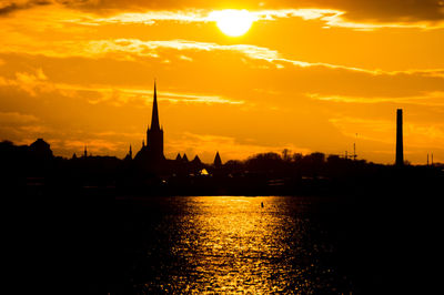 Scenic view of river against sky at sunset