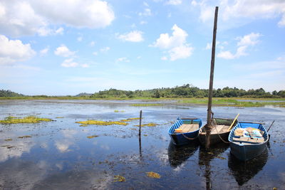 Boats moored in lake against sky