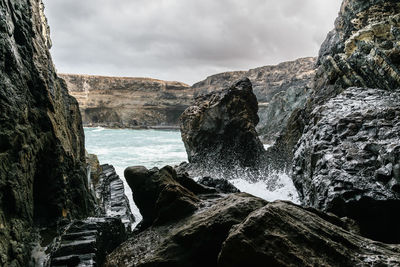 Scenic view of rocks in sea against sky