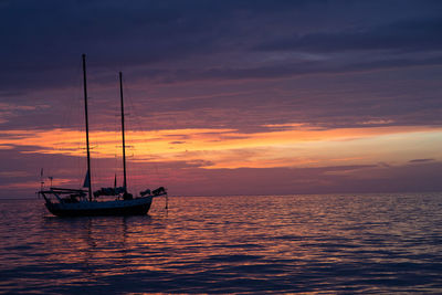 Boat sailing in sea at sunset