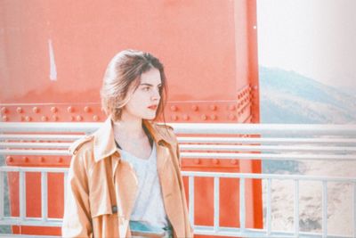 Full length of woman standing against railing