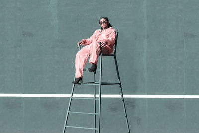 Portrait of girl sitting on chair in court