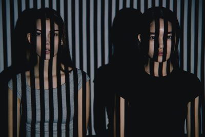 Dark conceptual mystic portrait of young girls with projector lighting
