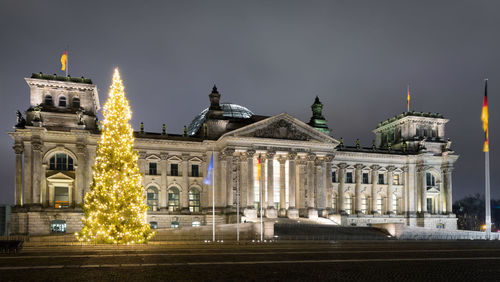 Illuminated christmas tree against the reichstag at night