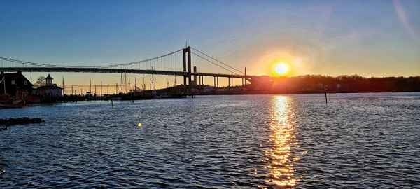 Bridge over river against sky during sunset