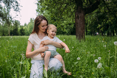 Portrait of happy friends sitting on field