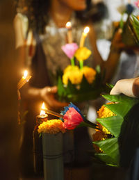 Blurred image of woman holding flowers with candles