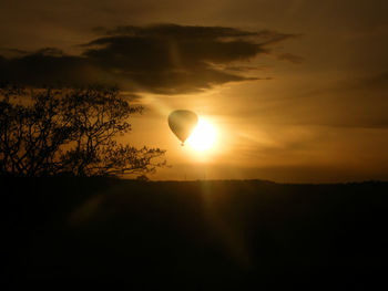 Scenic view of silhouette hot air balloon against sky during sunset