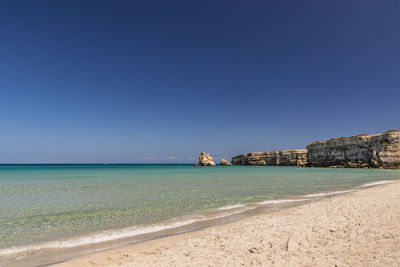 Scenic view of sea against clear blue sky