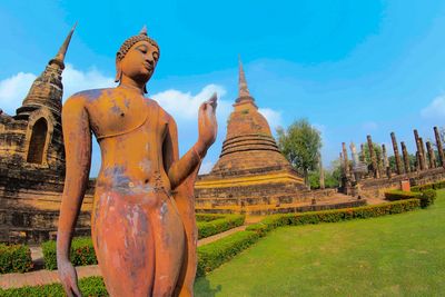 Statue against temple building against sky