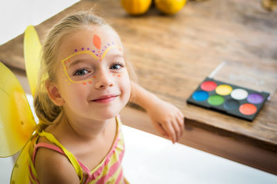 Close-up portrait of girl with face paint at home