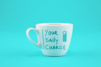 Close-up of coffee cup against blue background