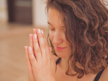 Close-up of young woman meditating in yoga studio