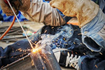 Cropped image of welder welding metal