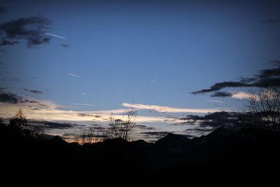 Silhouette trees on landscape against sky during sunset