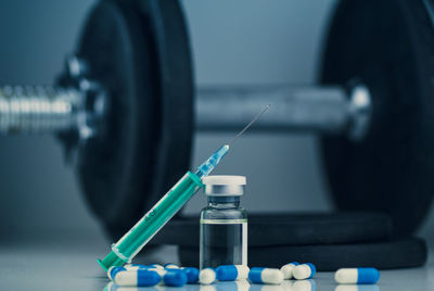 Dumbbells, syringe with needle, pills and vial with steroids. illegal doping in sport concept