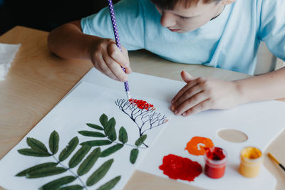 Midsection of girl drawing on table