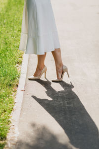 Low section of woman standing on footpath