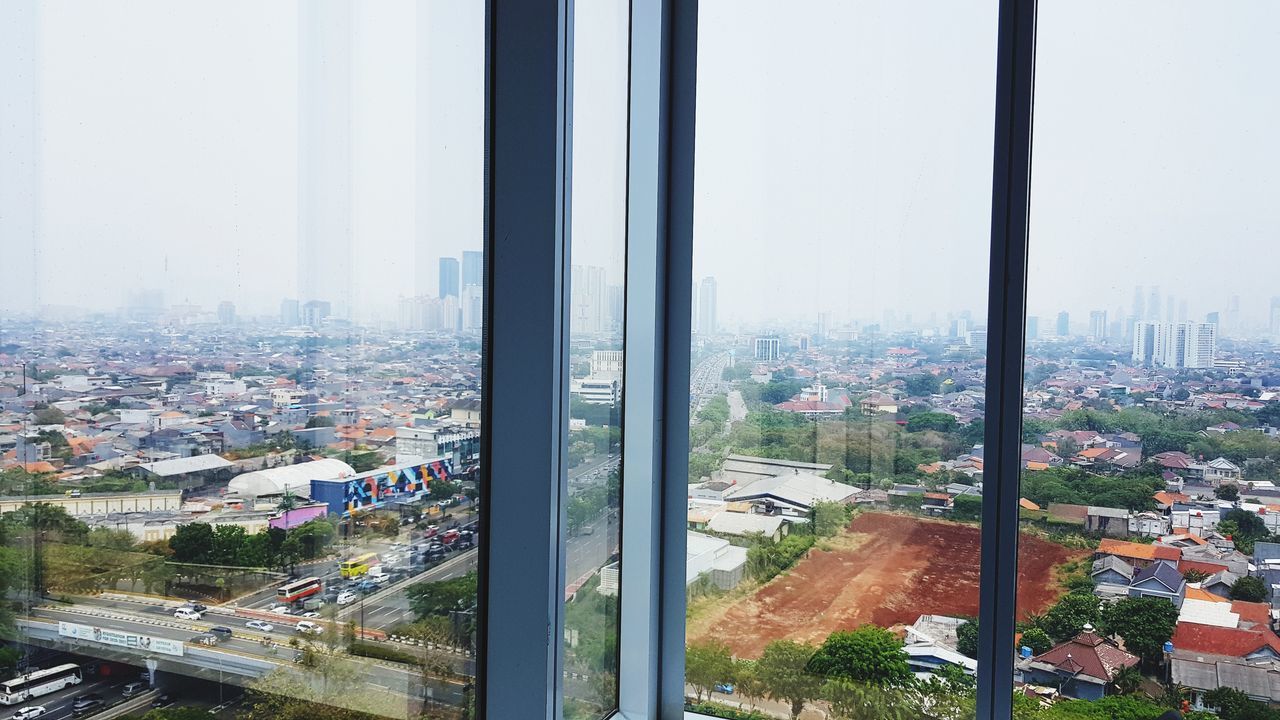 HIGH ANGLE VIEW OF CITY BUILDINGS SEEN THROUGH WINDOW