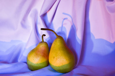 Close-up of fruits on table against blue wall