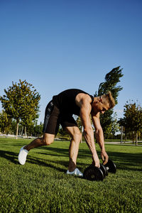 Man playing with ball on grass against sky