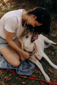 Happy woman having fun with her labrador outdoors.