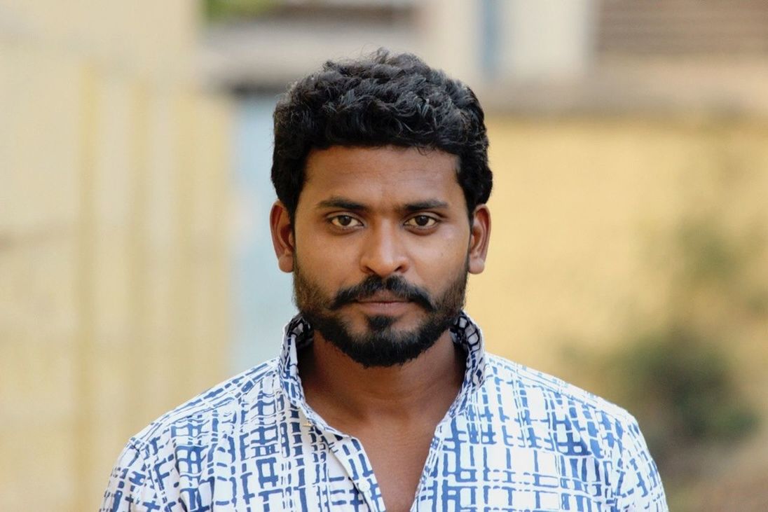 one person, front view, real people, focus on foreground, portrait, headshot, looking at camera, outdoors, beard, lifestyles, day, young adult, close-up, one man only, people