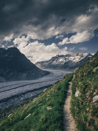 Road leading towards mountains against sky